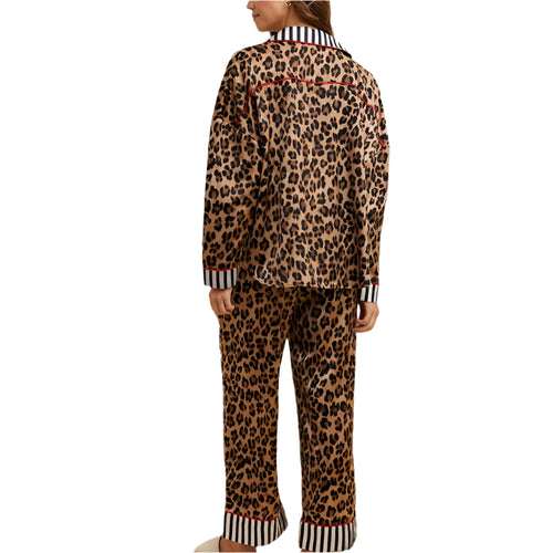 Person wearing leopard print pajamas in a bedroom setting