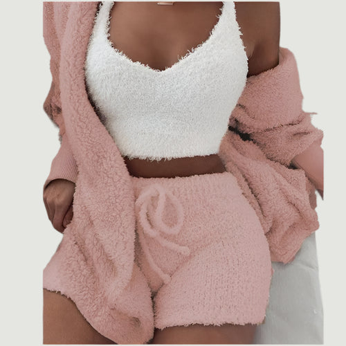Person wearing a white fuzzy top and pink fuzzy shorts with a matching pink robe.